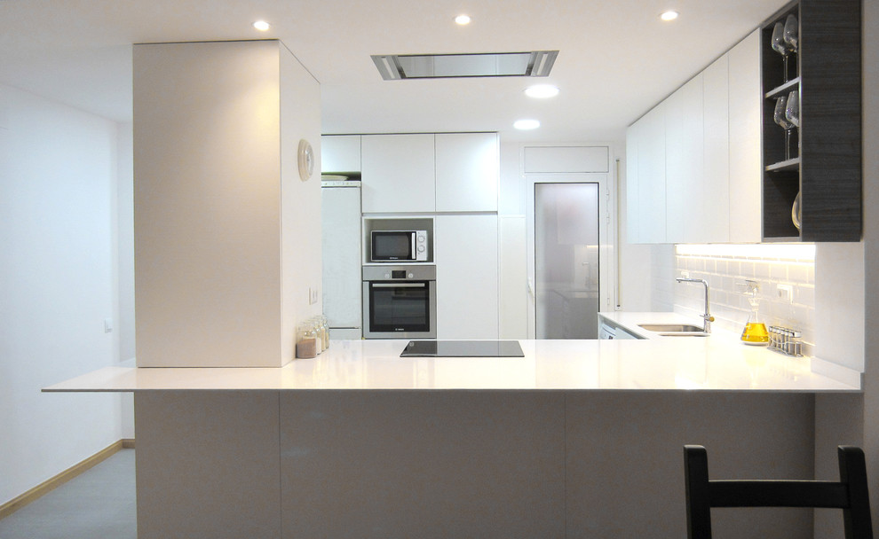 Идея дизайна: угловая кухня-гостиная среднего размера в скандинавском стиле с плоскими фасадами, белыми фасадами, белым фартуком, фартуком из плитки кабанчик и полуостровом
