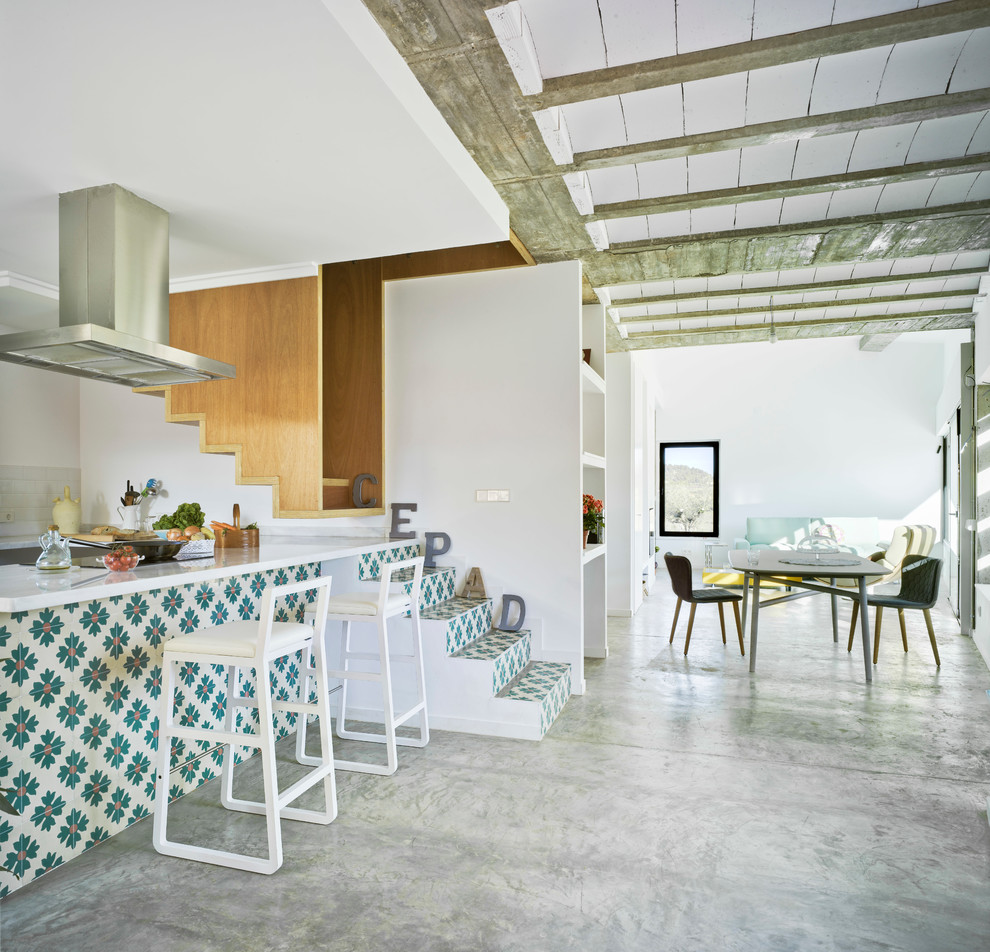 Esempio di una grande cucina design con pavimento in cemento, penisola, paraspruzzi bianco, top in superficie solida e elettrodomestici in acciaio inossidabile