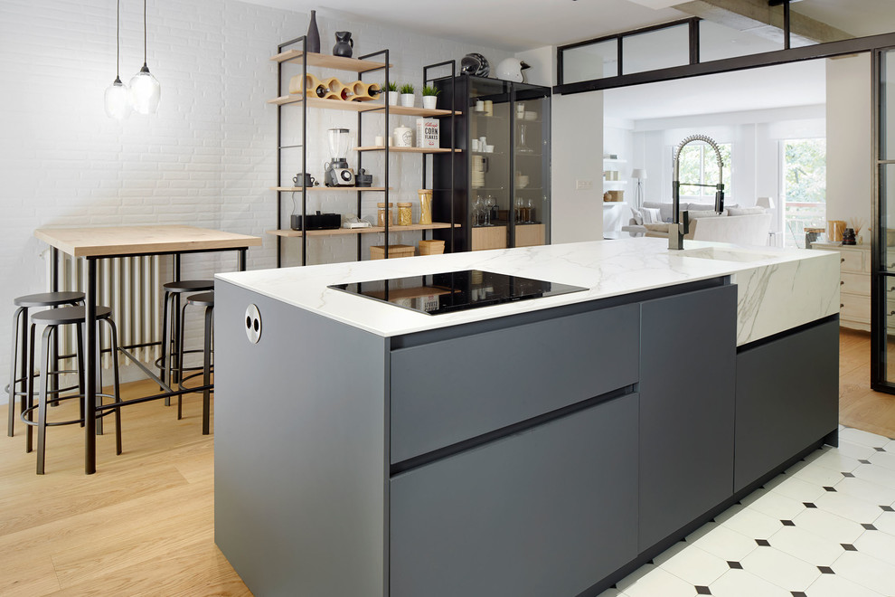 Zweizeilige Skandinavische Küche mit integriertem Waschbecken, flächenbündigen Schrankfronten, grauen Schränken, hellem Holzboden, Kücheninsel und beigem Boden in Sonstige