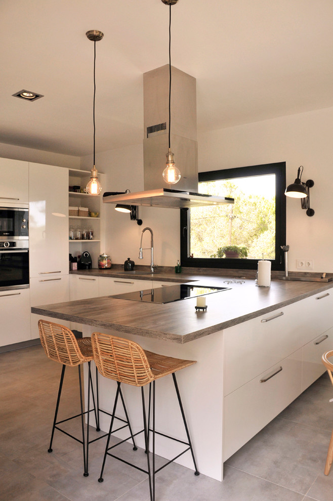 バルセロナにある高級な中くらいなコンテンポラリースタイルのおしゃれなキッチン (シングルシンク、フラットパネル扉のキャビネット、白いキャビネット、シルバーの調理設備) の写真