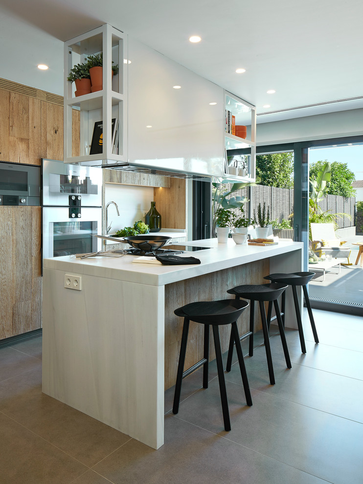 Photo of a large mediterranean single-wall open plan kitchen in Barcelona with flat-panel cabinets, medium wood cabinets, ceramic flooring and an island.