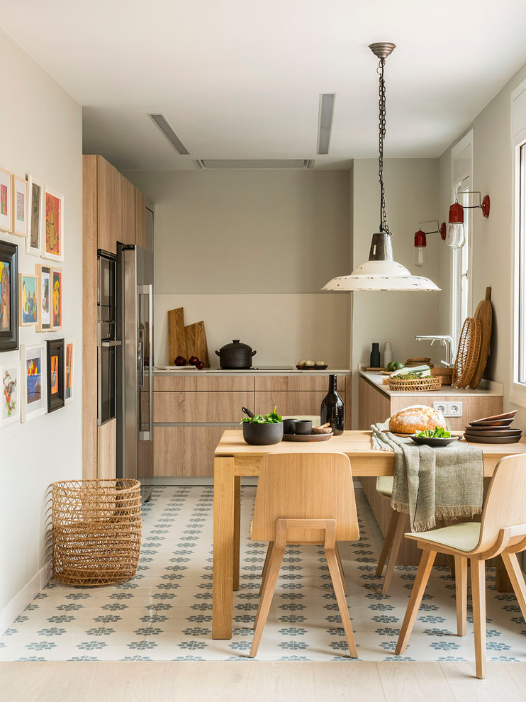 Imagen de cocina costera, de tamaño medio, sin isla, con fregadero integrado, armarios con paneles lisos, puertas de armario de madera clara, encimera de laminado, salpicadero beige, electrodomésticos de acero inoxidable, encimeras beige y suelo multicolor