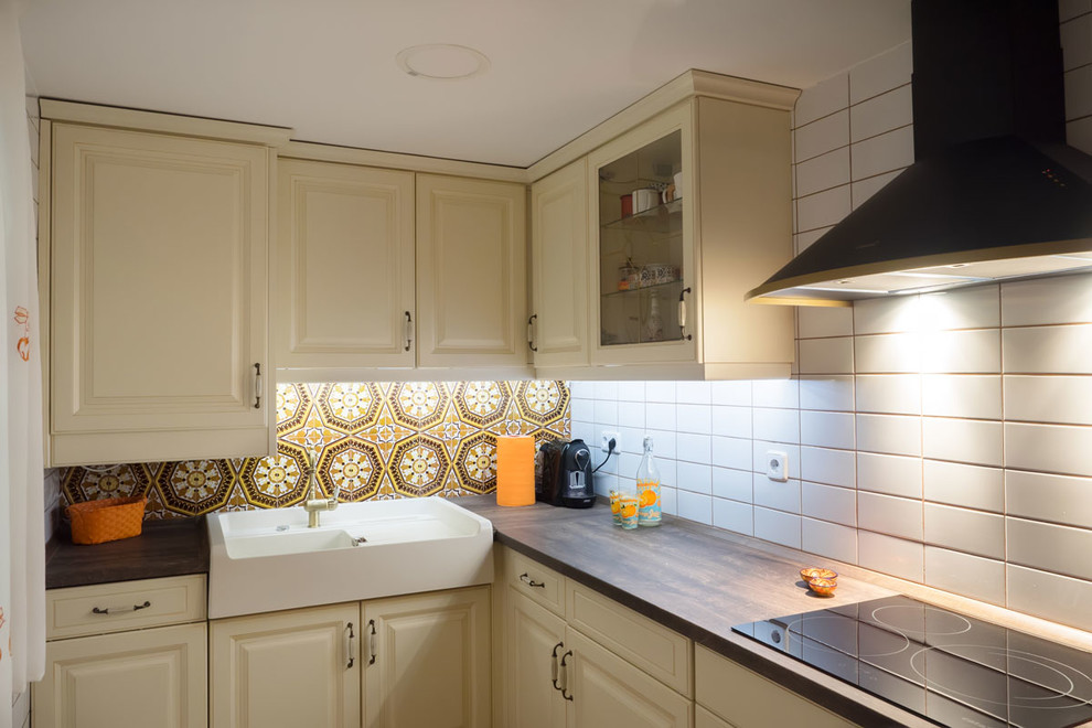 Bild på ett mellanstort, avskilt retro l-kök, med en nedsänkt diskho, luckor med upphöjd panel, vita skåp, träbänkskiva, vitt stänkskydd, stänkskydd i keramik, färgglada vitvaror och klinkergolv i keramik