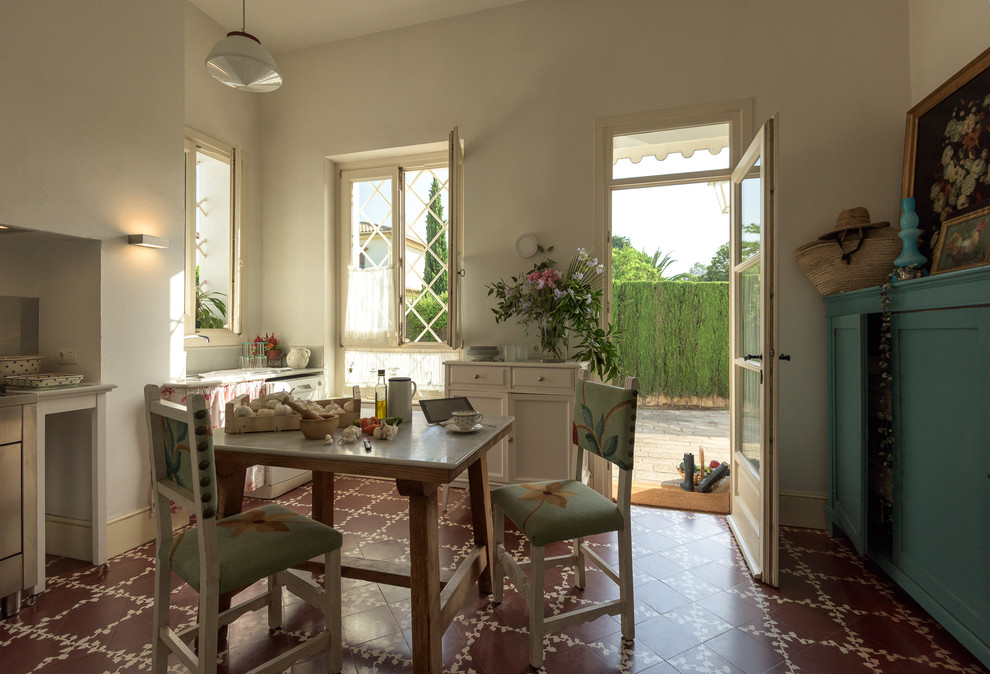 Cette image montre une salle à manger ouverte sur la cuisine style shabby chic de taille moyenne avec un sol en carrelage de céramique et un mur blanc.