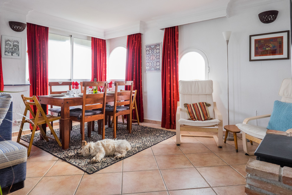 Immagine di una sala da pranzo mediterranea chiusa e di medie dimensioni con pareti bianche, pavimento in terracotta e nessun camino