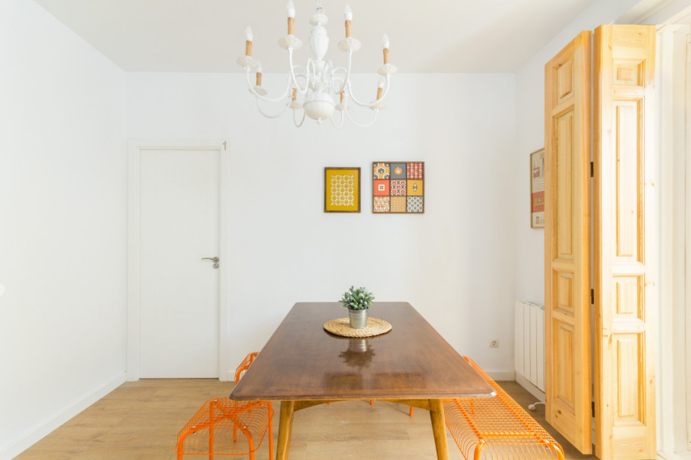 Inspiration for a mid-sized scandinavian laminate floor and brown floor dining room remodel in Madrid with white walls