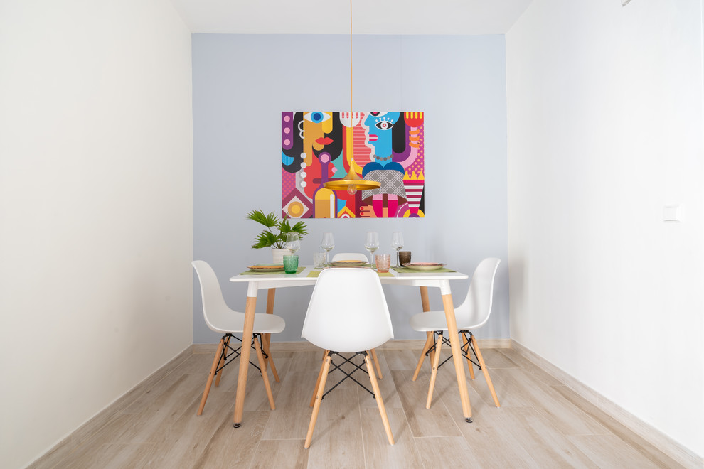 Example of a danish light wood floor and beige floor enclosed dining room design in Malaga with white walls