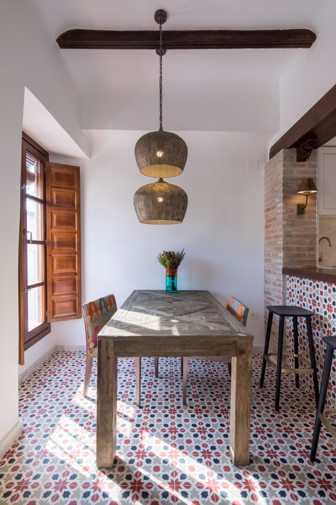 Foto di una sala da pranzo aperta verso la cucina mediterranea di medie dimensioni con pareti bianche, pavimento multicolore e pavimento con piastrelle in ceramica