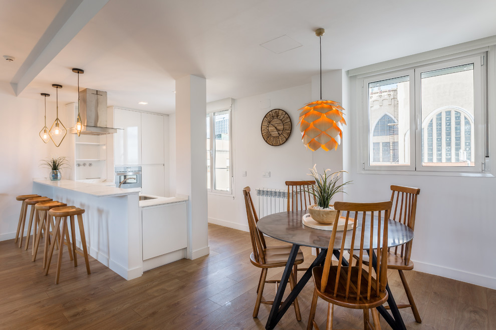 Foto di una sala da pranzo aperta verso la cucina minimal di medie dimensioni con pareti bianche, pavimento in legno massello medio, nessun camino e pavimento marrone
