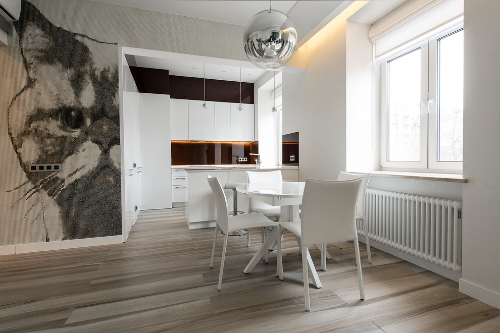 Aménagement d'une salle à manger ouverte sur le salon contemporaine avec un mur blanc et parquet clair.