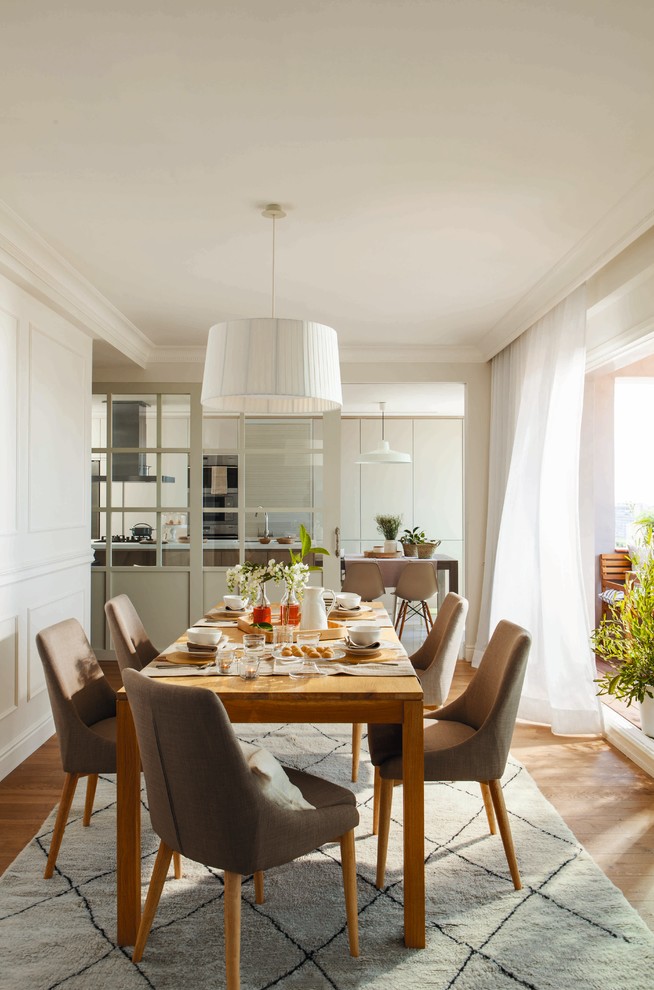 This is an example of a medium sized scandi enclosed dining room in Other with white walls, medium hardwood flooring and no fireplace.
