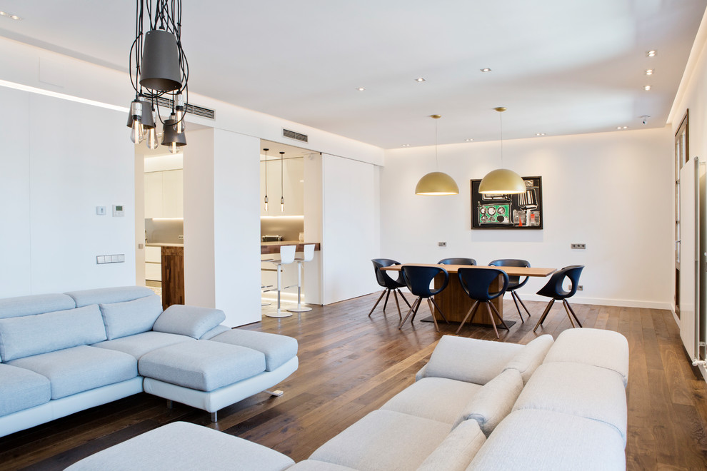 Photo of a large contemporary open plan dining room in Barcelona with white walls, medium hardwood flooring, a ribbon fireplace, a metal fireplace surround and brown floors.
