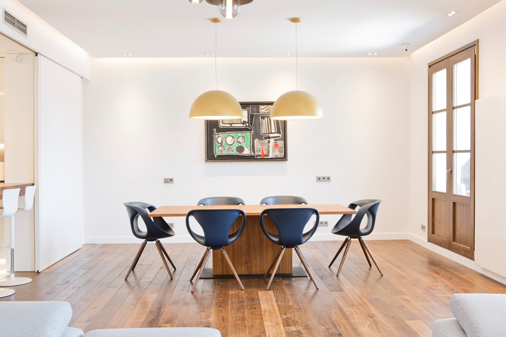 Photo of a large contemporary open plan dining room in Barcelona with white walls, medium hardwood flooring and no fireplace.