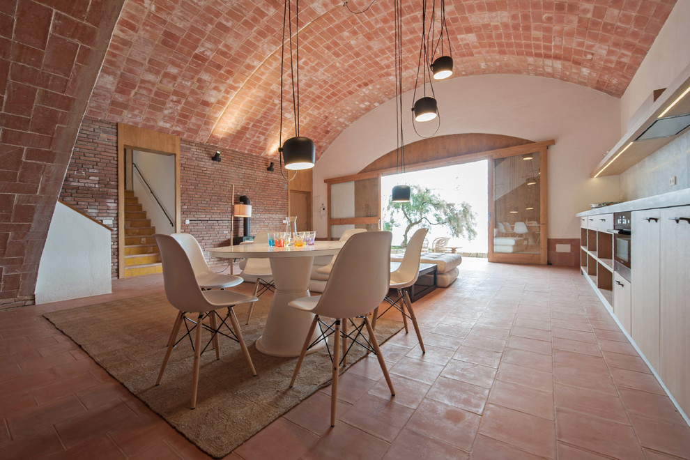 Foto de comedor mediterráneo grande abierto sin chimenea con paredes blancas y suelo de baldosas de terracota