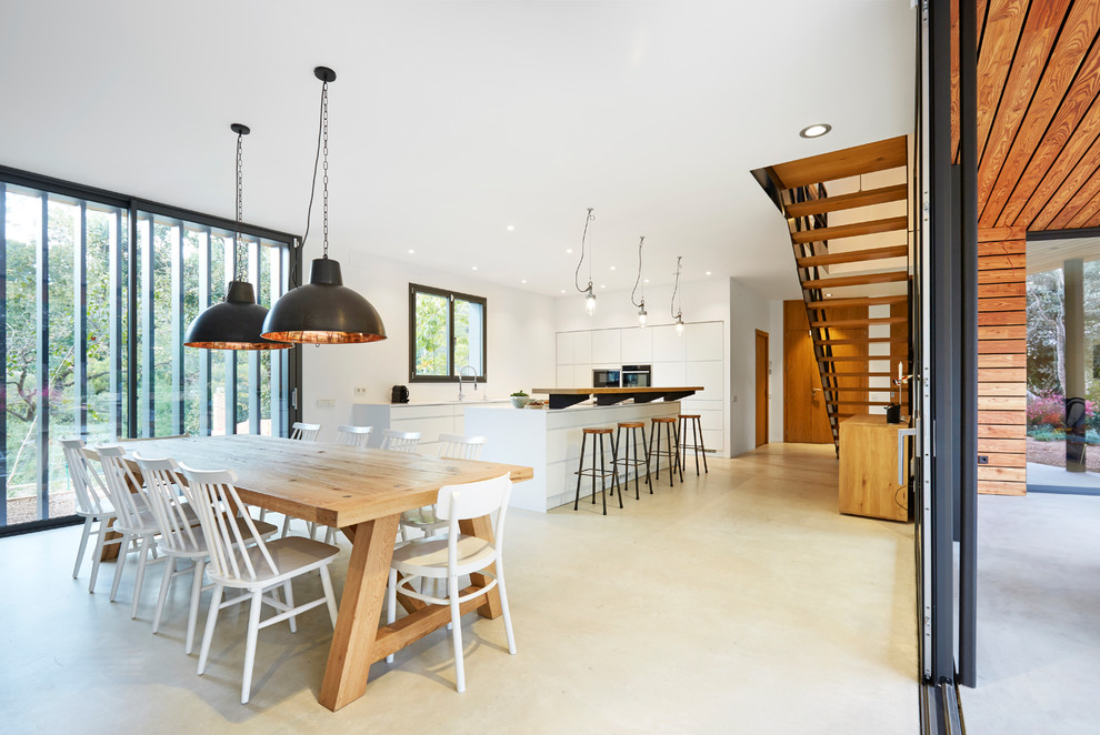 Источник вдохновения для домашнего уюта: огромная гостиная-столовая в скандинавском стиле с бежевым полом, белыми стенами и бетонным полом