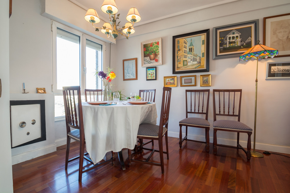 Immagine di una sala da pranzo country chiusa con pareti bianche, parquet scuro e pavimento marrone