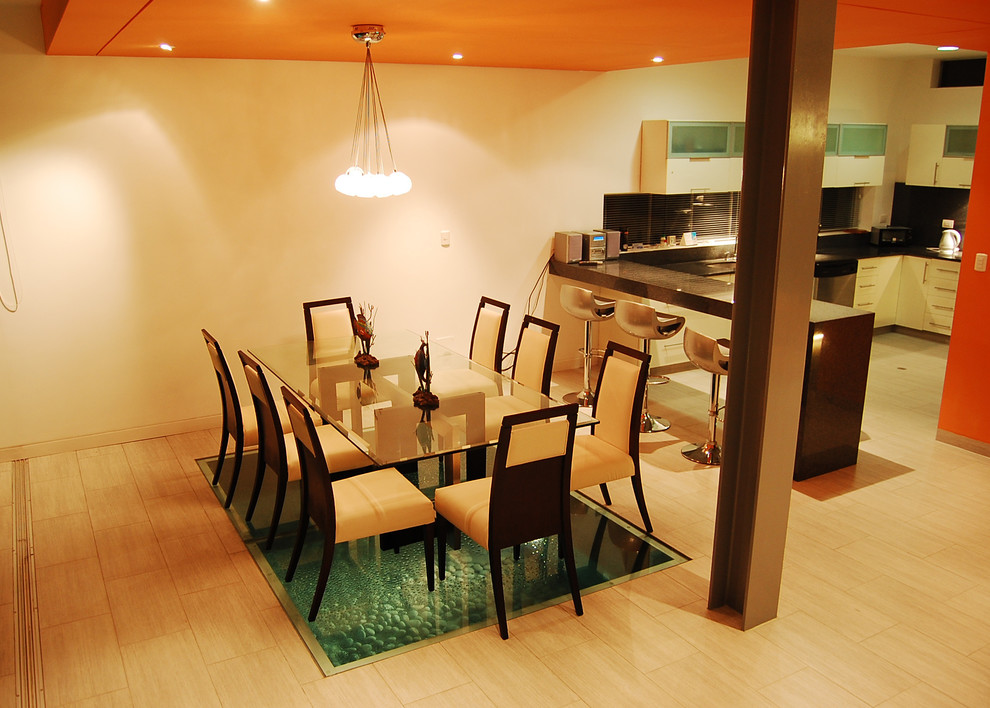 Foto di una sala da pranzo aperta verso la cucina tropicale di medie dimensioni con pareti multicolore, pavimento in gres porcellanato e nessun camino