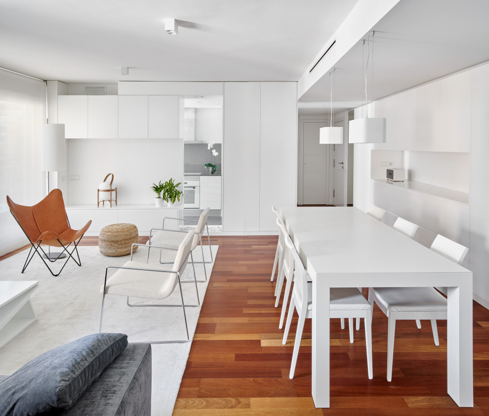 Inspiration pour une salle à manger design avec un mur blanc, un sol en bois brun, une cheminée ribbon et un manteau de cheminée en plâtre.