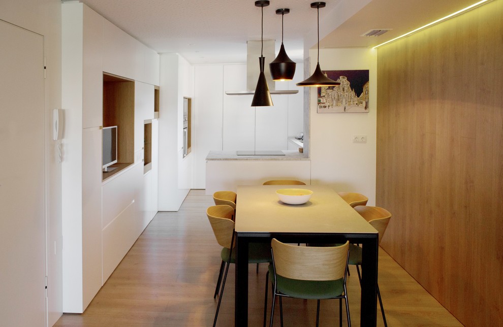 Immagine di una sala da pranzo aperta verso la cucina moderna con pareti bianche, pavimento in legno massello medio e pavimento beige