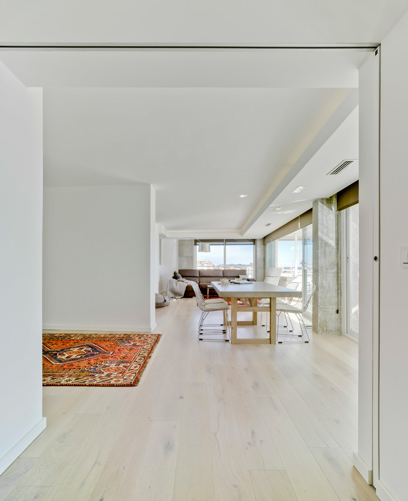 Exemple d'une grande salle à manger ouverte sur le salon tendance avec un mur blanc, parquet clair, aucune cheminée et un sol beige.