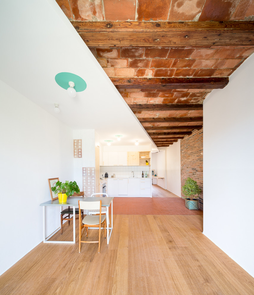Offenes, Mittelgroßes Industrial Esszimmer ohne Kamin mit weißer Wandfarbe und braunem Holzboden in Barcelona