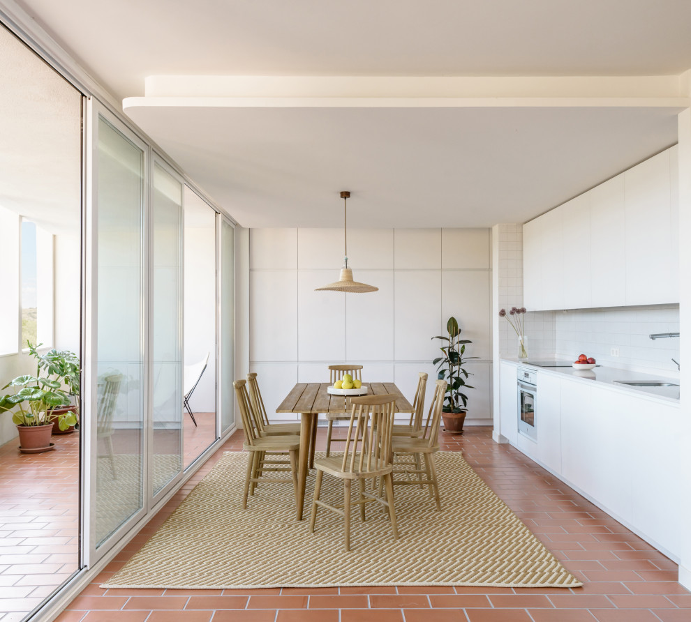 Ispirazione per una sala da pranzo mediterranea con pareti bianche e pavimento rosso