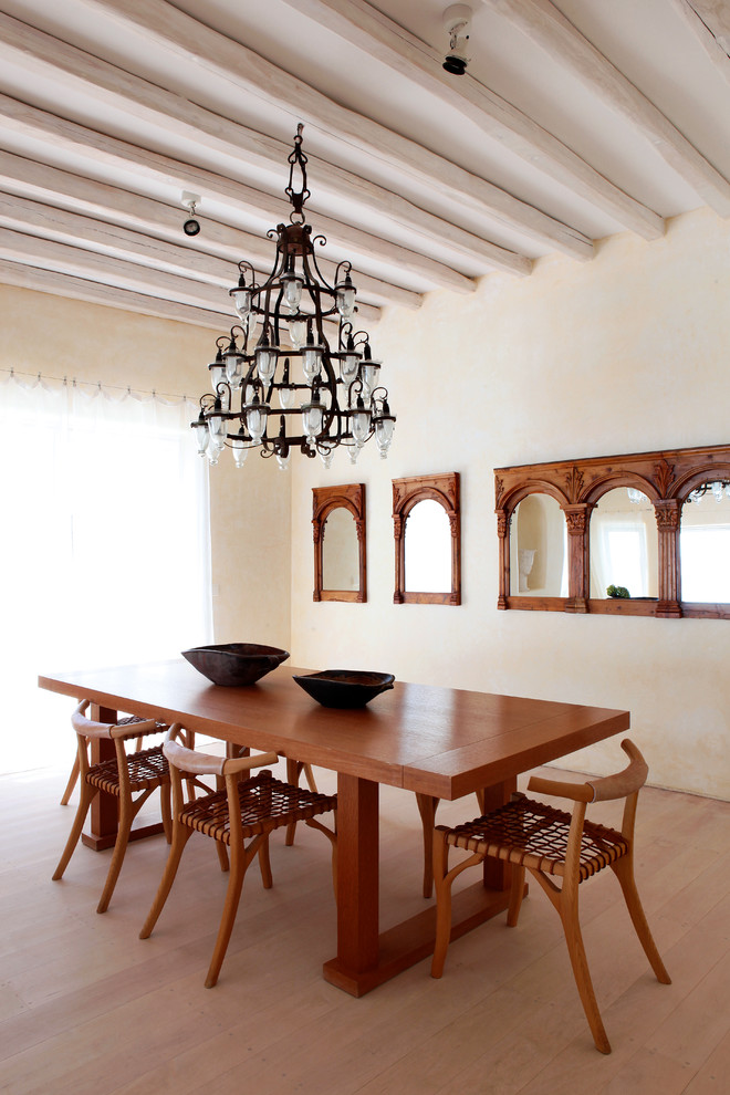 Diseño de comedor mediterráneo grande abierto con paredes beige y suelo de madera clara