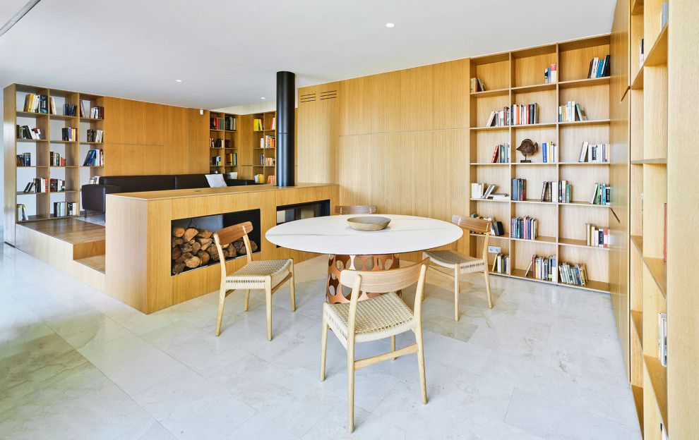 Modelo de comedor minimalista abierto con estufa de leña, marco de chimenea de metal, suelo beige y madera