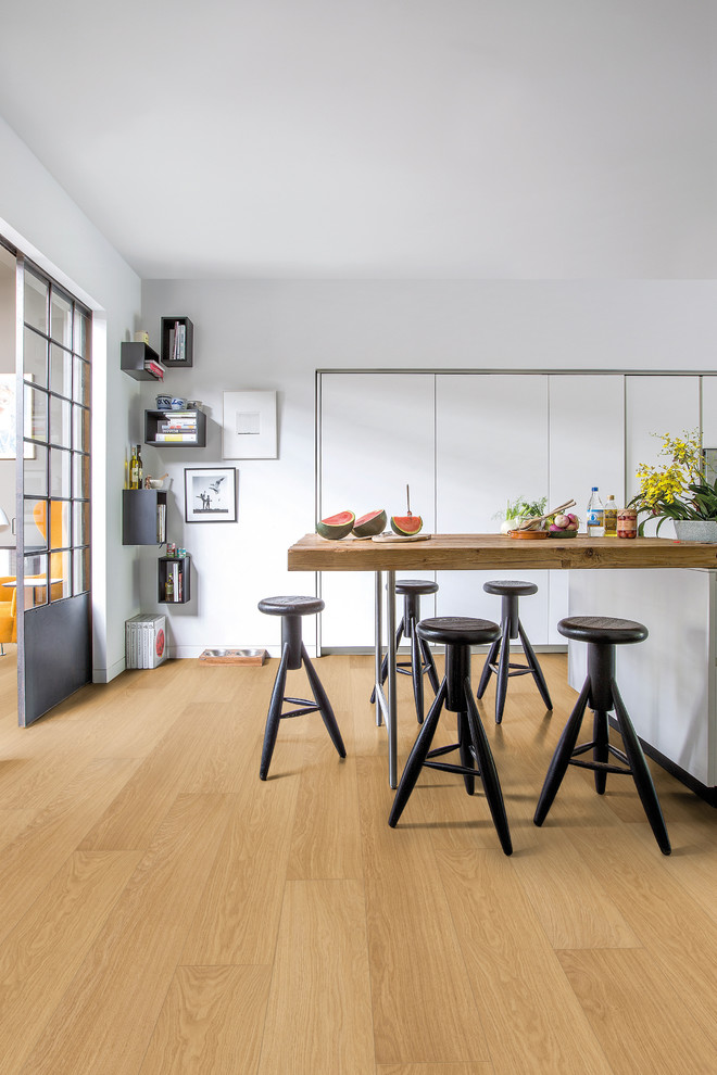 Idée de décoration pour une grande salle à manger ouverte sur la cuisine design avec un mur blanc, un sol en bois brun et aucune cheminée.