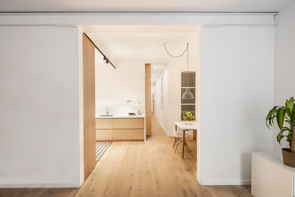 Inspiration pour une salle à manger ouverte sur le salon nordique de taille moyenne avec un mur blanc et un sol en bois brun.