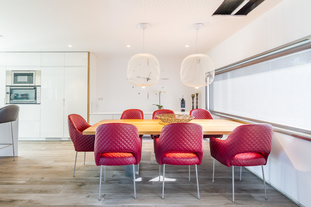 Imagen de comedor de cocina contemporáneo con paredes blancas, suelo de madera clara y suelo gris