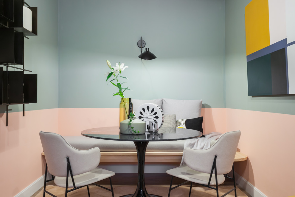 Cette photo montre une salle à manger ouverte sur la cuisine scandinave de taille moyenne avec un mur rose et un sol en bois brun.