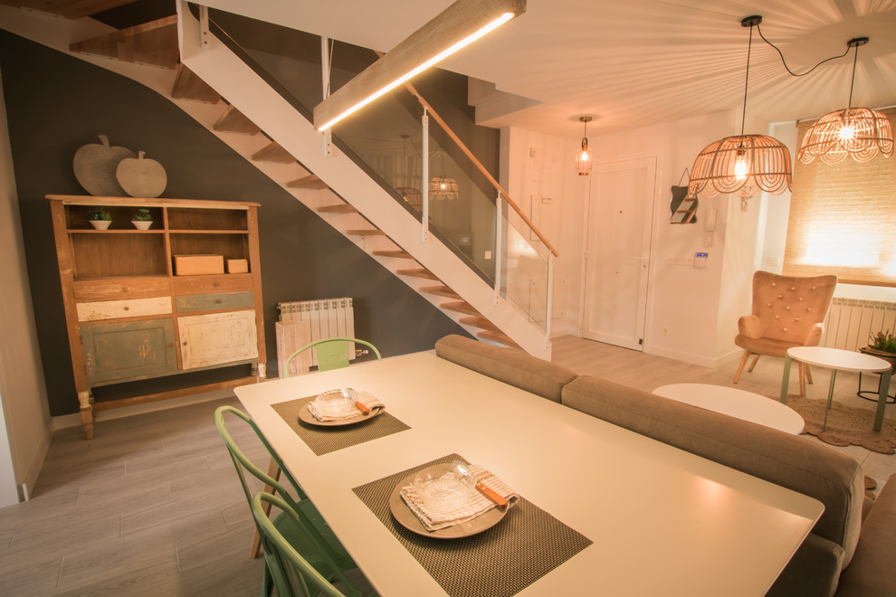 Immagine di una sala da pranzo aperta verso la cucina minimal di medie dimensioni con pareti bianche e pavimento in laminato
