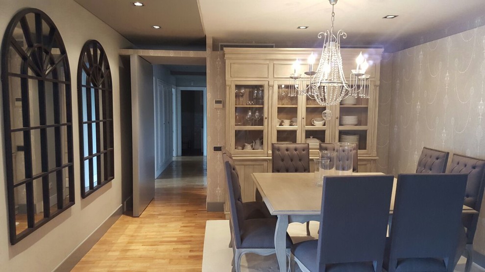 Imagen de comedor clásico renovado de tamaño medio abierto con paredes grises, suelo de madera clara y suelo beige