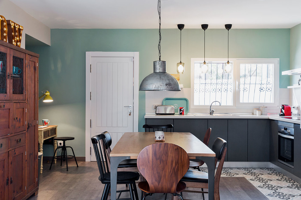 Стильный дизайн: гостиная-столовая среднего размера в скандинавском стиле с зелеными стенами, полом из ламината и серым полом - последний тренд