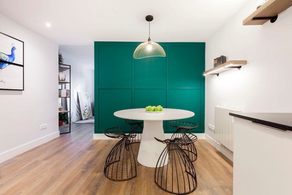 Réalisation d'une salle à manger design avec un mur vert, un sol en bois brun et un sol marron.