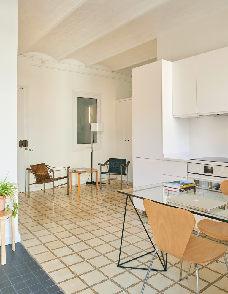 Foto di una piccola sala da pranzo aperta verso la cucina mediterranea con pareti bianche e pavimento con piastrelle in ceramica