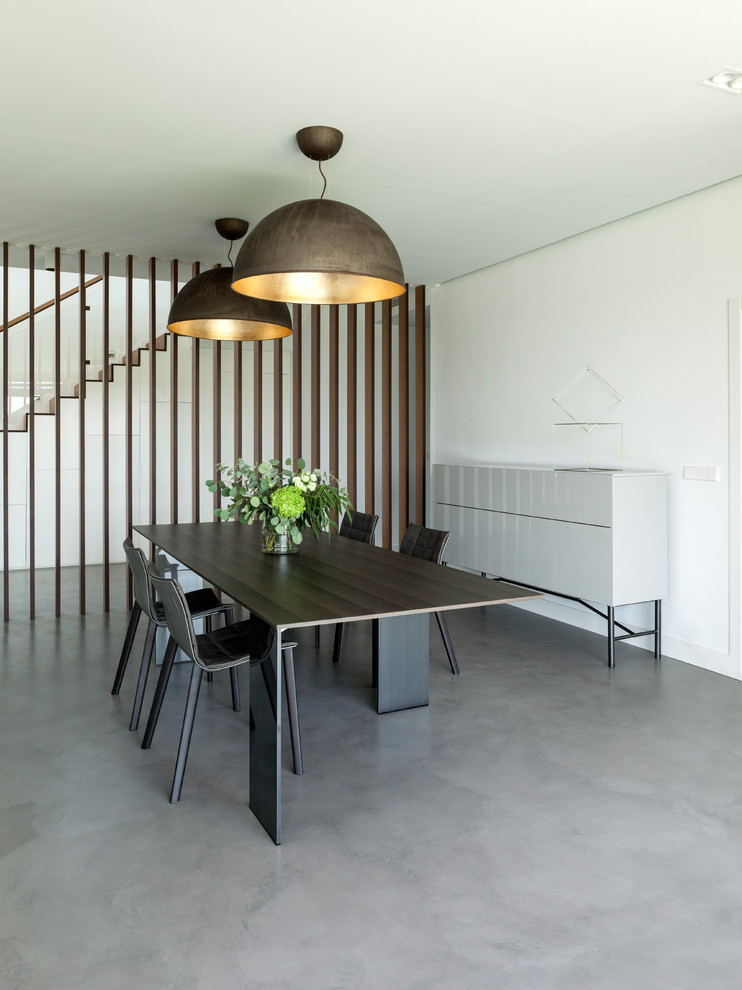 Идея дизайна: столовая в современном стиле с белыми стенами, бетонным полом и серым полом
