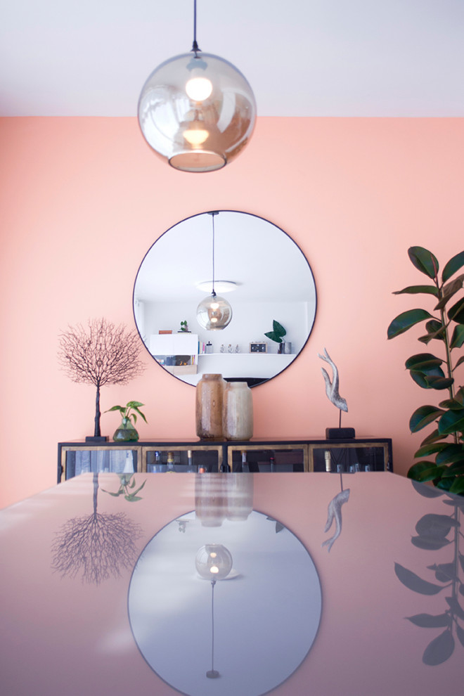 Esempio di una sala da pranzo aperta verso il soggiorno moderna di medie dimensioni con pareti rosa, pavimento in cemento e pavimento grigio