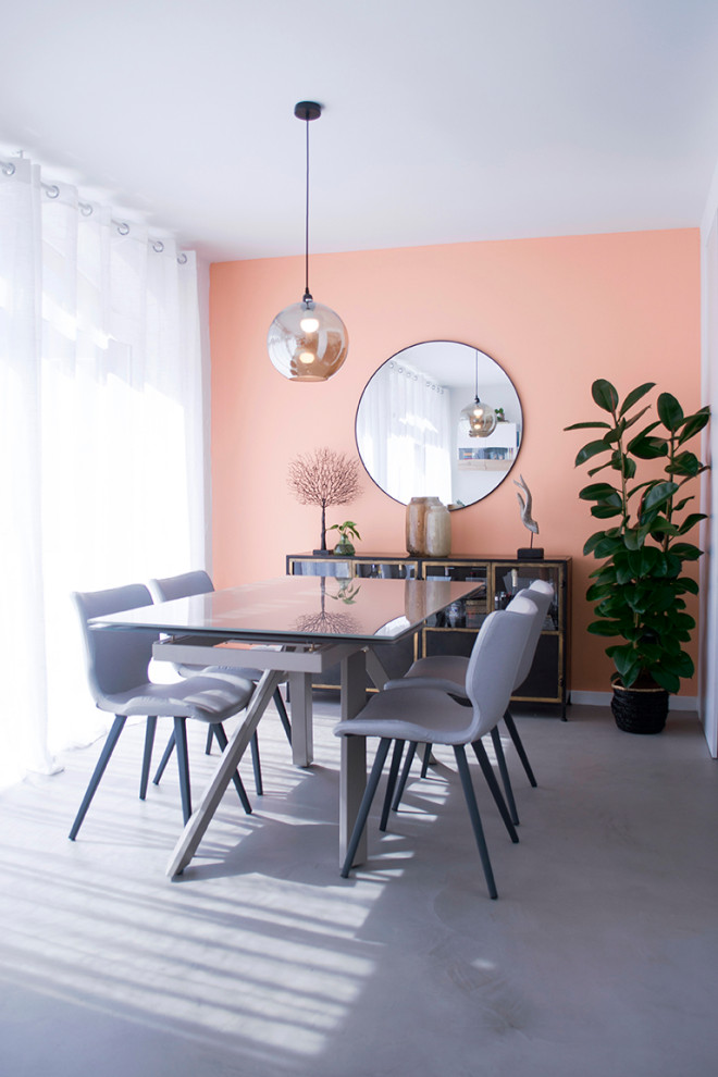 Immagine di una sala da pranzo aperta verso il soggiorno moderna di medie dimensioni con pavimento in cemento, pavimento grigio e pareti rosa