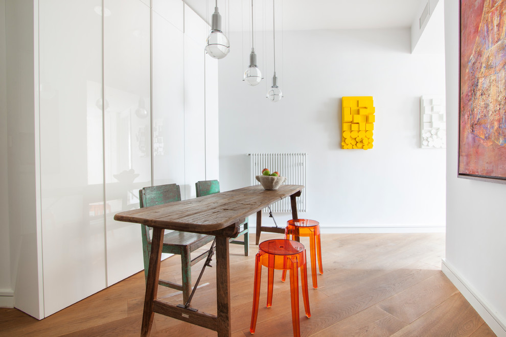 Geschlossenes, Mittelgroßes Modernes Esszimmer ohne Kamin mit weißer Wandfarbe und braunem Holzboden in Madrid