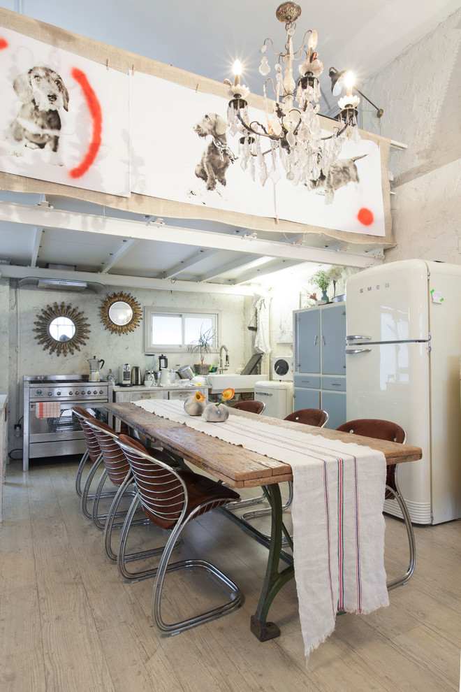 Foto de comedor de cocina ecléctico grande sin chimenea con paredes blancas y suelo de madera clara