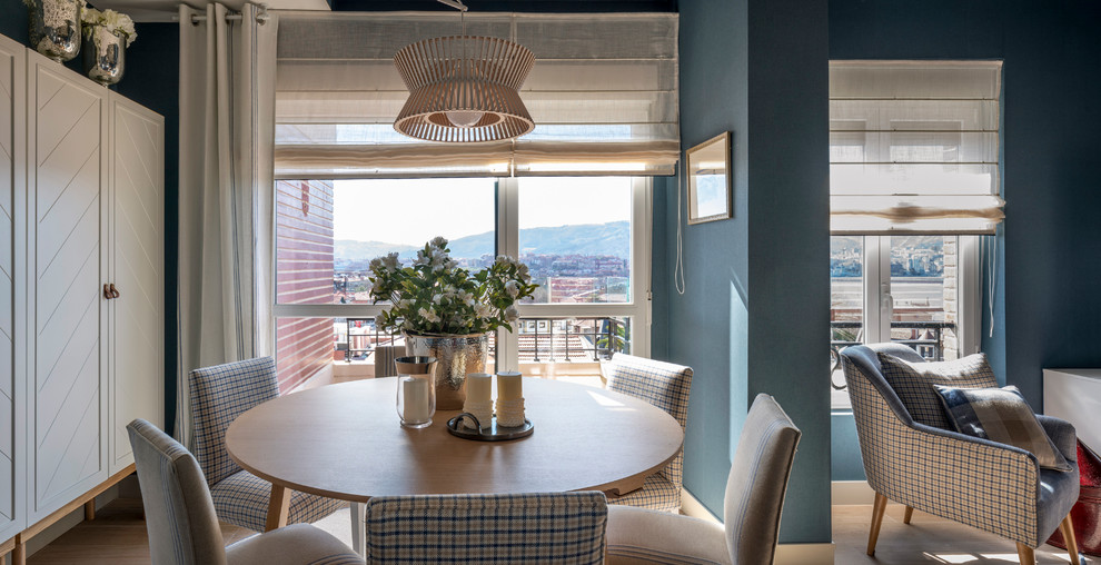 Foto di una sala da pranzo aperta verso il soggiorno tradizionale di medie dimensioni con pareti blu, parquet chiaro, nessun camino e pavimento marrone