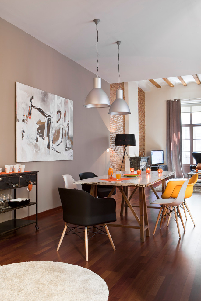 Idée de décoration pour une salle à manger ouverte sur le salon urbaine de taille moyenne avec parquet foncé, aucune cheminée et un mur gris.