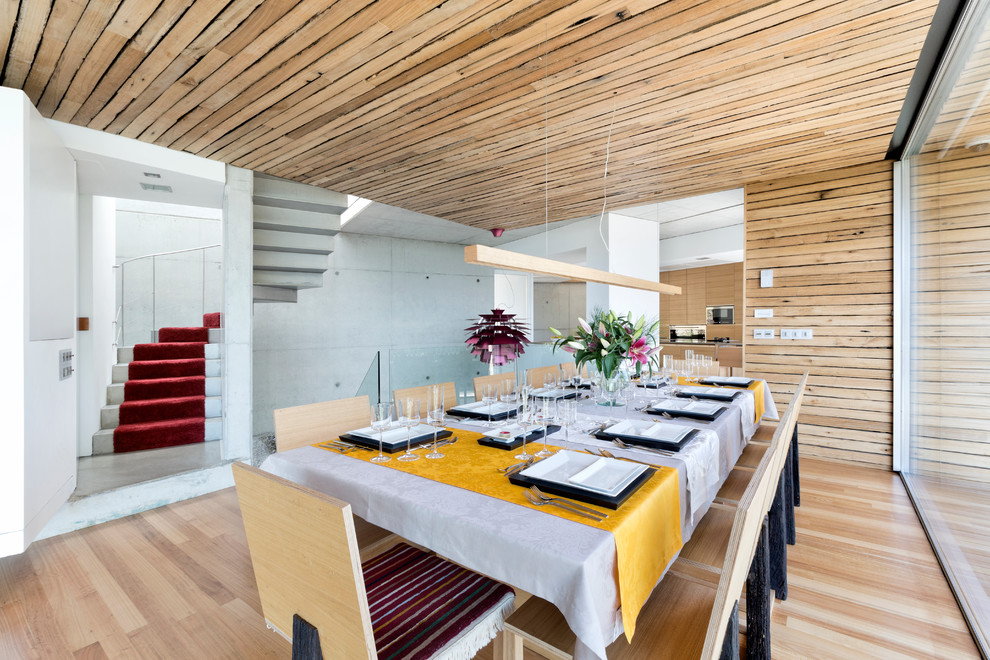 Ispirazione per una grande sala da pranzo aperta verso il soggiorno minimal con pareti marroni e parquet chiaro