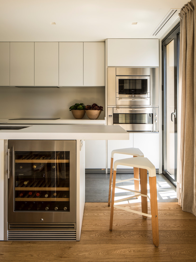 Immagine di una sala da pranzo aperta verso la cucina nordica di medie dimensioni con pareti bianche, nessun camino, pavimento marrone e parquet chiaro