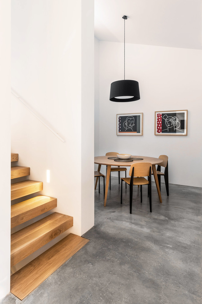 Example of a trendy concrete floor and gray floor dining room design in Madrid with white walls and no fireplace