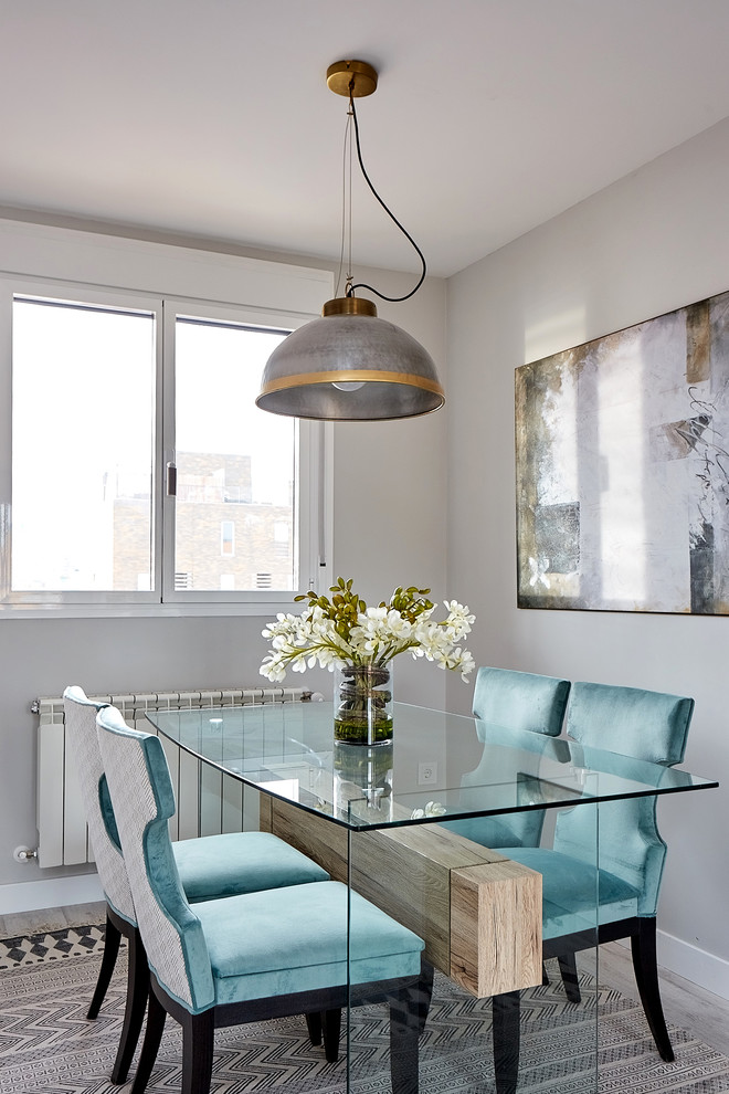 This is an example of a contemporary dining room in Madrid with grey walls, light hardwood flooring and grey floors.