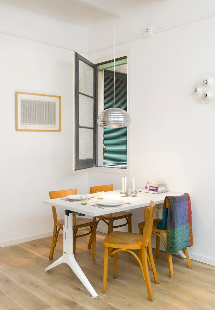 Immagine di una sala da pranzo aperta verso il soggiorno design di medie dimensioni con pareti bianche, pavimento in legno massello medio e nessun camino