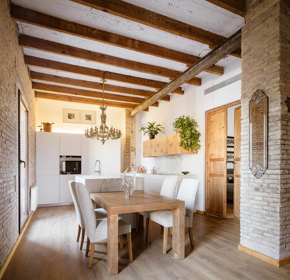 Inspiration pour une salle à manger ouverte sur la cuisine traditionnelle de taille moyenne avec un mur blanc, un sol en bois brun, aucune cheminée et un sol marron.